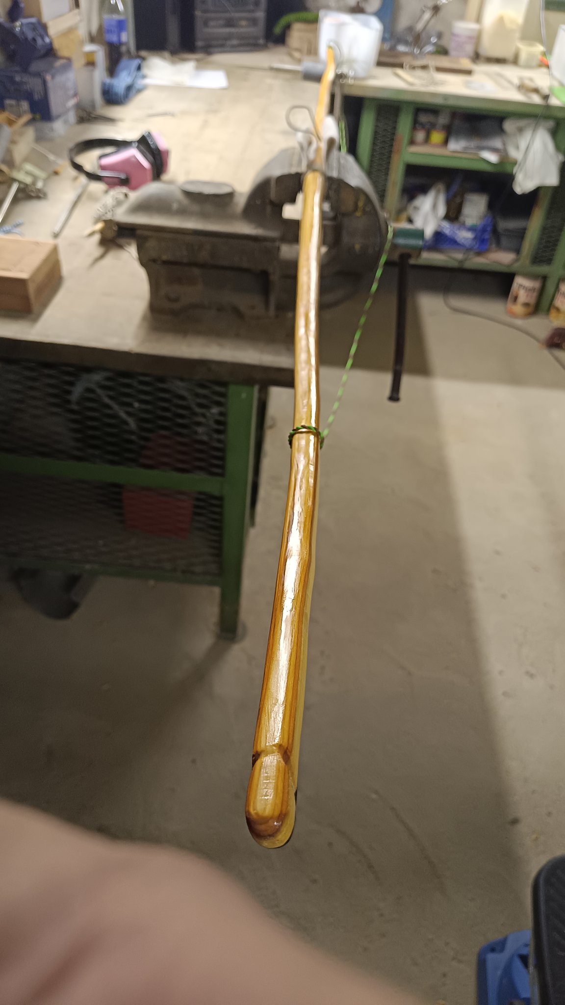 Blick über die Länge des Bogens, wobei sich der Hintere Wurfarm nur noch unscharf abbildet. Das Wurfarmende vor uns ist noch glänzend vom aufgetragenen Öl und die orangene rötliche Farbe leuchtet noch